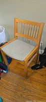 Front view of slat-back wooden chair with upholstered seat