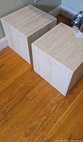 Two travertine cube tables on hardwood floor