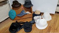 Group shot of all hats arranged around open wicker basket