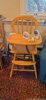 Full view of wooden high chair with monitor set on tray