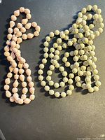 Pink and cream/grey bead necklaces laid out