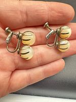 Pair of screw-back earrings in hand showing overall design and double moonstones