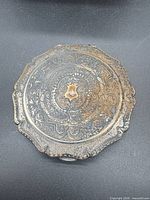 Top view showing ornate engraving and scalloped edge