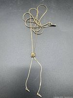 Full view of extra-long gold-tone necklace with drop ends