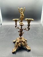Full view of gilt bronze candelabra showing cherub, two arms, base