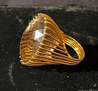 Side view of gold ring showing large faceted smoky quartz and wire basket setting
