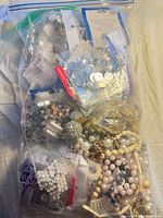 Full view of sealed gallon bag packed with assorted beads, rhinestones and jewelry parts