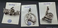 Three sterling charms on original BMC cards