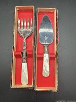 Both serving pieces in their red-lined tartan boxes