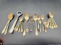 Full lot laid out showing all spoons and bottle opener