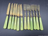 Full set laid out showing six knives and six forks with green handles