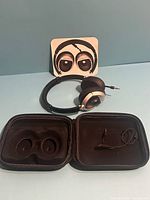 Headphones, carry case opened, instruction card visible