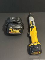 Screwdriver with battery installed next to charger