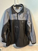 Front view of black and gray rain jacket hanging