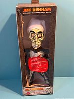 Front view of sealed Achmed animatronic doll in window box
