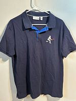 Front view of navy Lacoste polo shirt on hanger