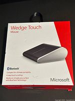 Front of boxed Microsoft Wedge Touch mouse showing product image and features