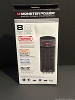 Front view of sealed Monster Power EXP 800 retail box showing product image and key features such as eight outlets and fireproof protection.