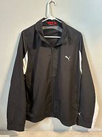 Front view showing zip closure, chest logo, white sleeve panel