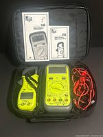 Open carrying case showing both meters, manuals and leads
