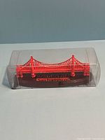 Side view of plastic Golden Gate Bridge model in clear case
