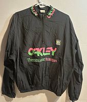 Front view of Oakley black windbreaker with graphics