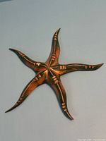 Front view of wooden starfish showing carved details and paint finish