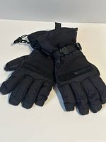 Front view of black WindRiver winter gloves showing wrist straps and branding
