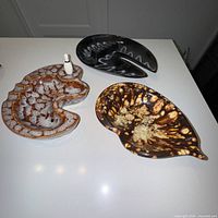 All three ceramic ashtrays side by side on tabletop