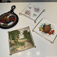 Front view of all four trivets showing designs and frames