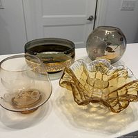 Group shot of four glass bowls showing shapes, colors and gold accents
