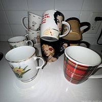Group shot of nine assorted ceramic mugs on countertop