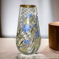 Full view of tall clear glass vase with blue, green, gold floral decoration