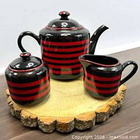 Full view of teapot, sugar bowl and creamer showing pattern and scale