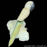 Full view of carved stone parrot mounted on quartz base