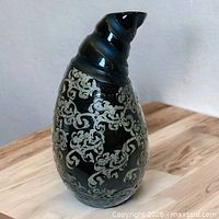 Front view of curved black vase with grey pattern