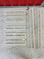 All seven cream metal shelves laid out showing sizes