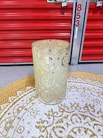 Full view of cylindrical etched glass vase standing upright