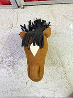 Front view of brown felt horse head with black mane