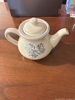 Left side view of teapot showing floral design, handle and spout