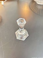 Front view of clear faceted glass candlestick holder on table