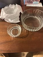 Three ribbed glass bowls nested on table