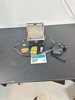 All items laid out: camera, case, manual, film boxes, loose cartridge