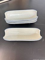 Stack of four corn-textured trays, top and side views