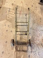 Top view of wooden hand truck showing wheels, frame, nose plate