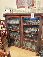 Front view of mahogany glass-front cabinet with contents visible