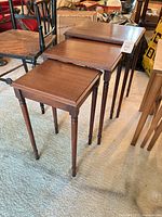 Three graduated mahogany nesting tables stacked