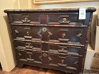 Front view showing four drawers, brass hardware, turned stiles