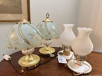 All four lamps: two frosted glass shade lamps and two milk glass hobnail lamps