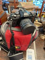 Olympus E-410 camera with lens resting on red camera bag